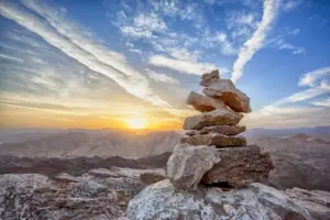 Rocas en balance con un hermoso paisaje del atardecer detras simbolizando la paz y la estabilidad obtenida luego de la terapia
